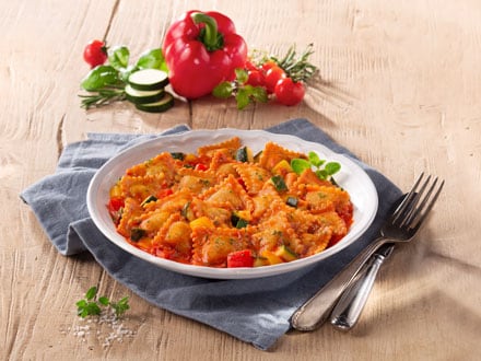 Teller mit Gemüse-Ravioli in Tomatensoße