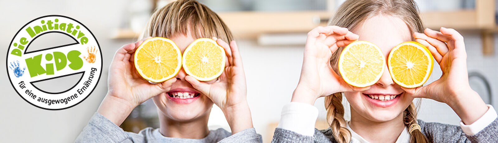 Initiative Kids - Zwei Kinder mit Orangenscheiben vor den Augen