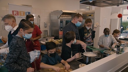 Unter der Anleitung von bofrost*Koch Tobias Terkatz kochen die beiden Prominenten gemeinsam mit den Kindern 