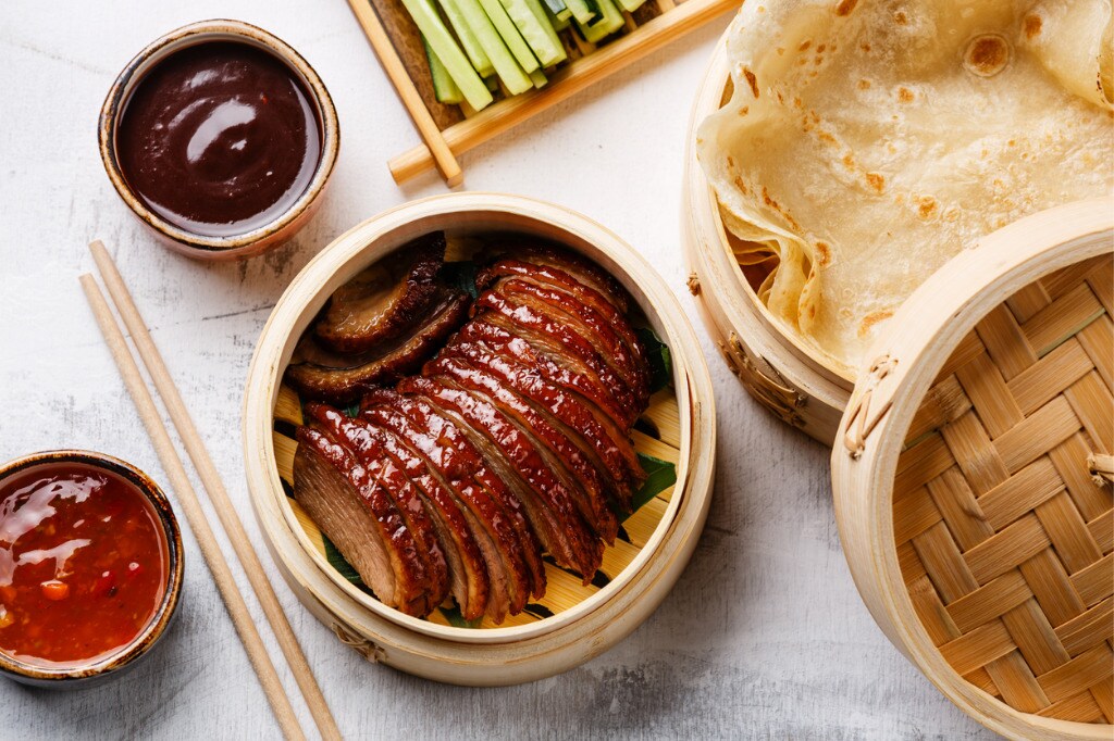 sliced-peking-duck-with-cucumber-green-onions-cilantro-and-wheaten-picture-id918057036.jpg