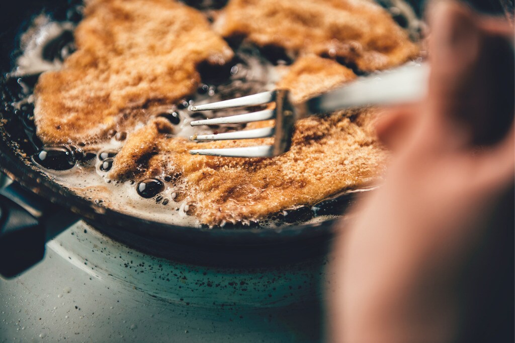 woman-frying-chicken-picture-id637772012.jpg