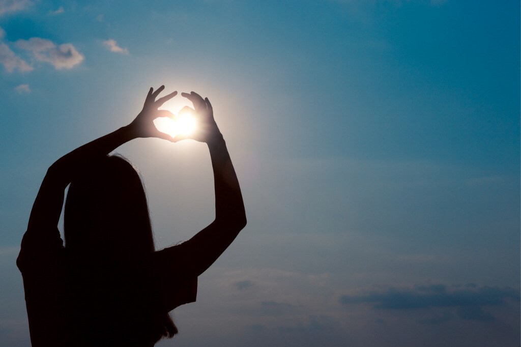 woman-making-heart-sign-gesture-in-sunset-sunlight-picture-id1040544430.jpg