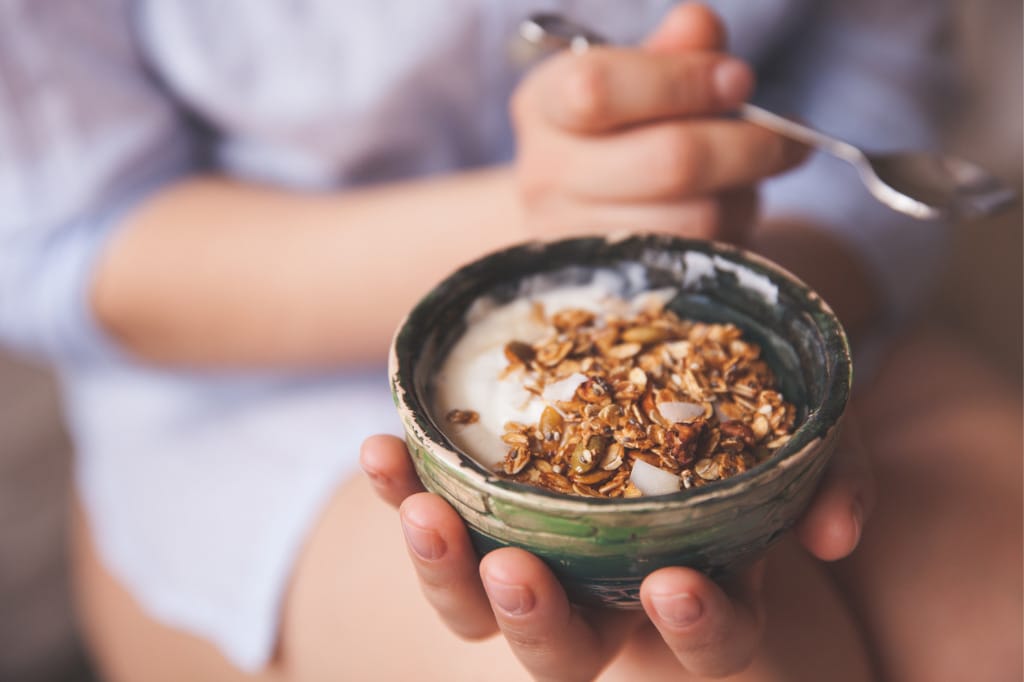 young-woman-with-muesli-bowl-girl-eating-breakfast-cereals-with-nuts-picture-id818390968.jpg